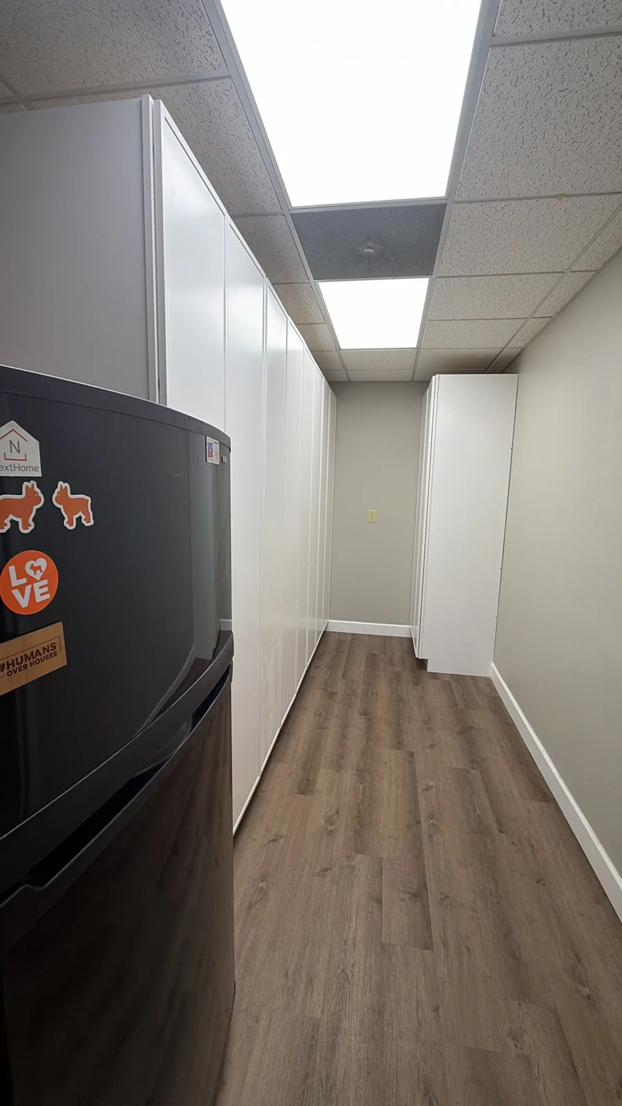 Tall white custom cabinets in an office breakroom